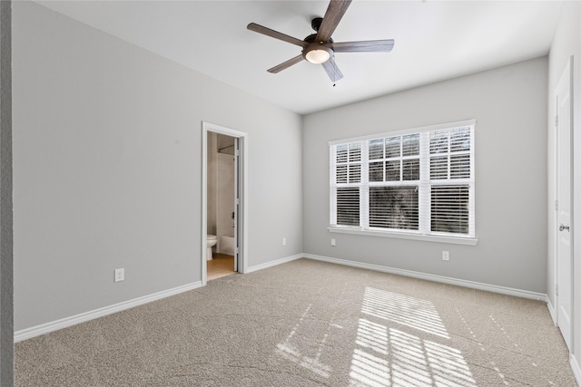 unfurnished bedroom featuring a ceiling fan, baseboards, connected bathroom, and light colored carpet