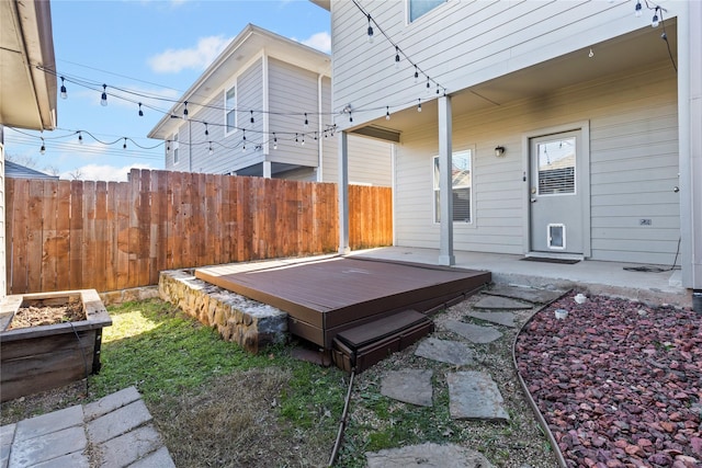 view of yard featuring fence, a deck, and a jacuzzi