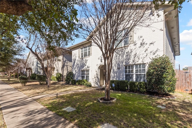 view of front of home featuring fence and a front lawn