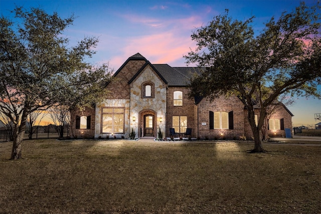 french country style house featuring a lawn