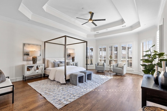 bedroom with ceiling fan, ornamental molding, dark hardwood / wood-style flooring, and a raised ceiling