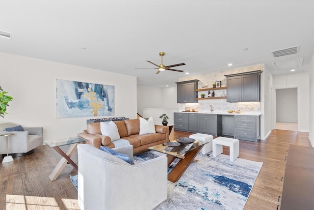 living room featuring ceiling fan and light hardwood / wood-style flooring