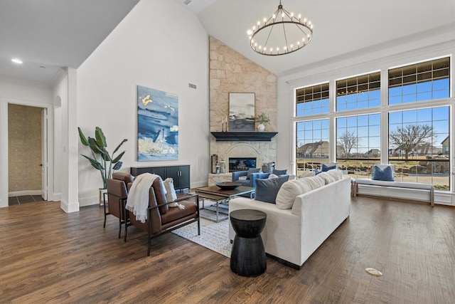 living room with a notable chandelier, a fireplace, high vaulted ceiling, and dark hardwood / wood-style floors