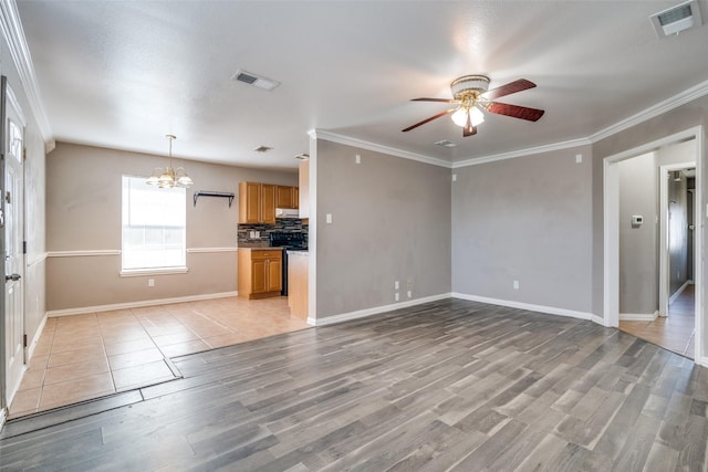 unfurnished living room with ceiling fan with notable chandelier, crown molding, and light hardwood / wood-style floors