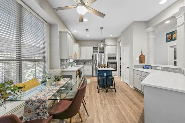 kitchen with a center island, a kitchen bar, sink, pendant lighting, and stainless steel appliances