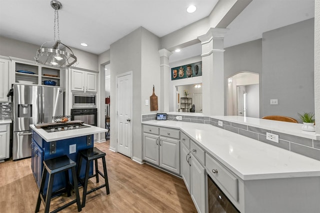 kitchen with black appliances, a kitchen bar, tasteful backsplash, white cabinets, and a kitchen island