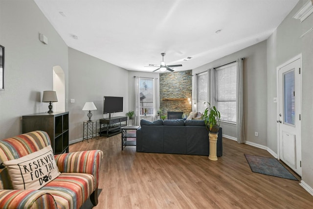 living room featuring ceiling fan, wood-type flooring, and a fireplace