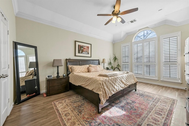 bedroom with crown molding, hardwood / wood-style flooring, vaulted ceiling, and ceiling fan