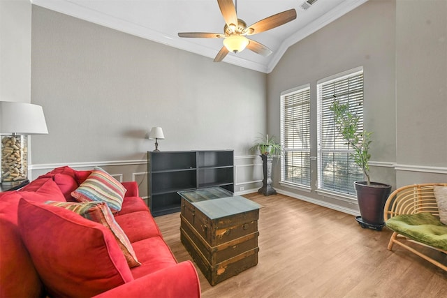 living room featuring ceiling fan, hardwood / wood-style flooring, lofted ceiling, and ornamental molding