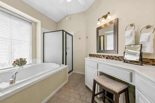 bathroom featuring ceiling fan, shower with separate bathtub, vanity, and vaulted ceiling