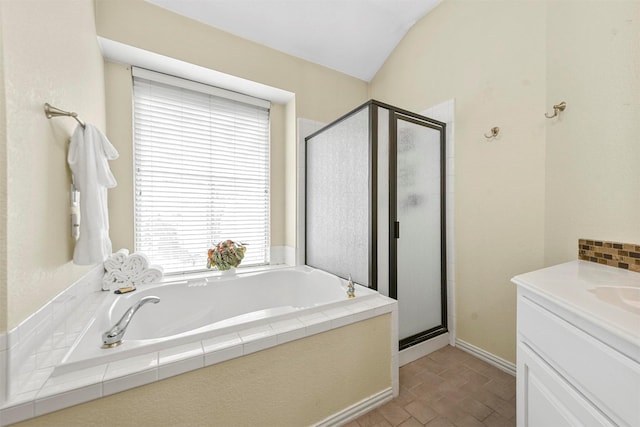 bathroom with independent shower and bath, lofted ceiling, and vanity