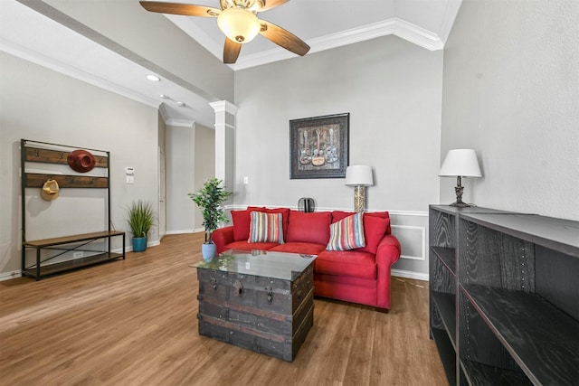 living room featuring decorative columns, hardwood / wood-style floors, ornamental molding, and ceiling fan