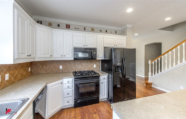 kitchen with decorative backsplash, white cabinetry, wood-type flooring, and black appliances