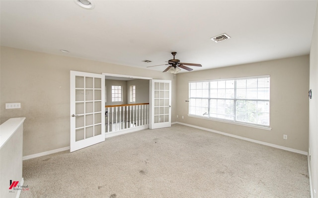 carpeted empty room featuring ceiling fan and french doors