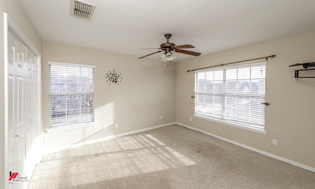 empty room featuring ceiling fan and carpet