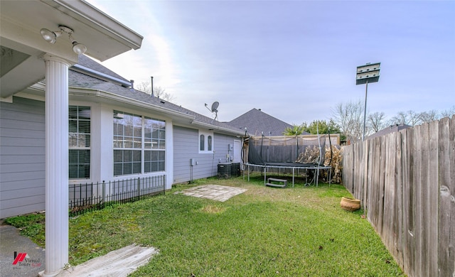 view of yard featuring central AC and a trampoline