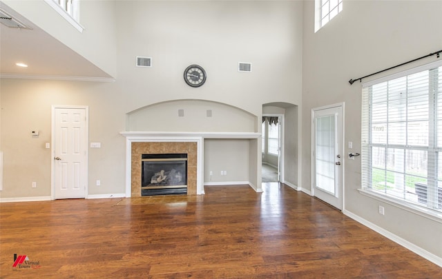 unfurnished living room with a towering ceiling and a healthy amount of sunlight