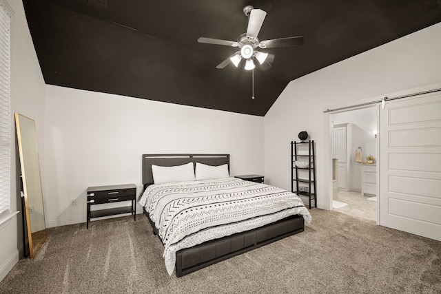 bedroom with ceiling fan, a barn door, ensuite bath, and carpet