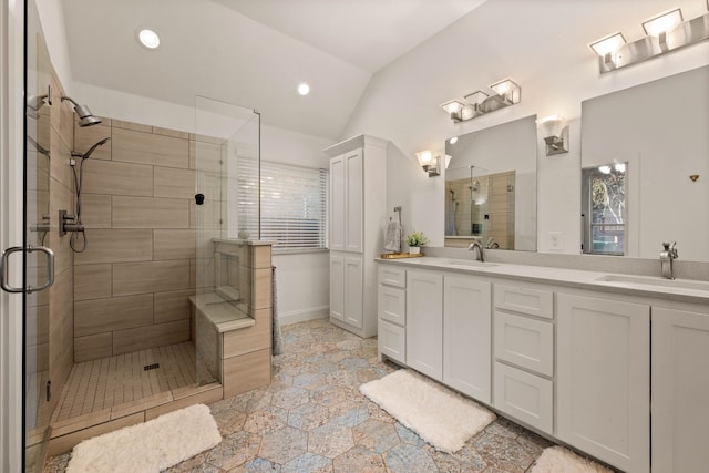 bathroom with lofted ceiling, a shower with shower door, and vanity