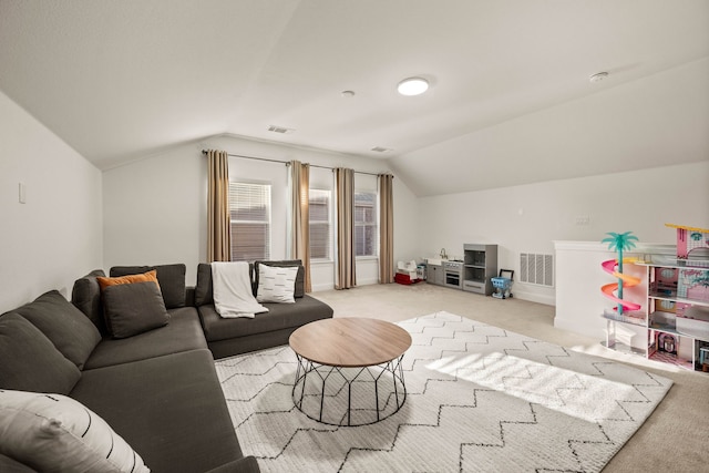 carpeted living room featuring vaulted ceiling