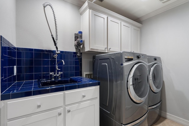 laundry room featuring sink, light tile patterned floors, washer and dryer, cabinets, and ornamental molding