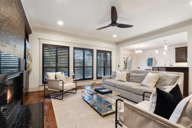 living room featuring a high end fireplace, ornamental molding, and light hardwood / wood-style floors