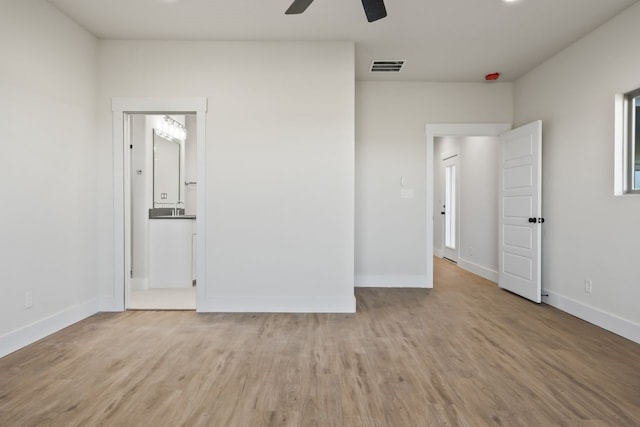 unfurnished bedroom featuring ceiling fan, ensuite bathroom, and light wood-type flooring