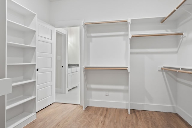 spacious closet with light hardwood / wood-style floors