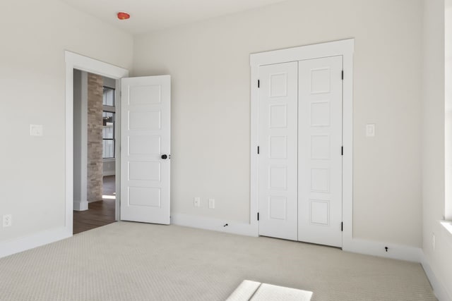 unfurnished bedroom with light carpet and a closet