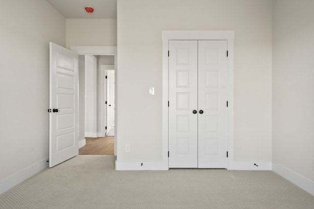 unfurnished bedroom with a closet and light carpet