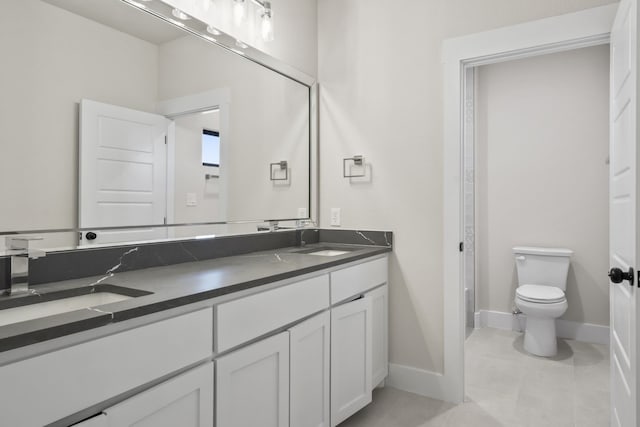 bathroom with toilet, tile patterned floors, and vanity