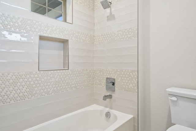 bathroom with washtub / shower combination and toilet