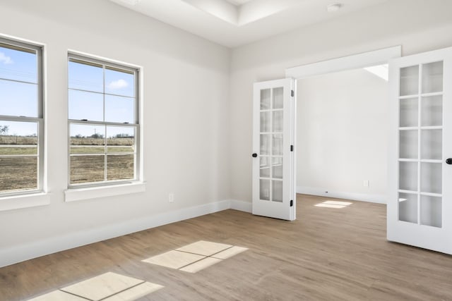 empty room with light hardwood / wood-style flooring and french doors