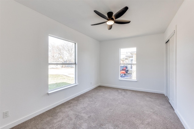 carpeted spare room with ceiling fan and a healthy amount of sunlight