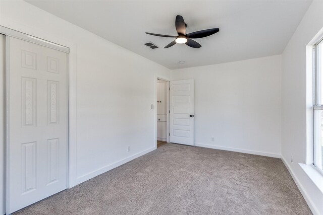 unfurnished bedroom featuring a closet, ceiling fan, and light carpet