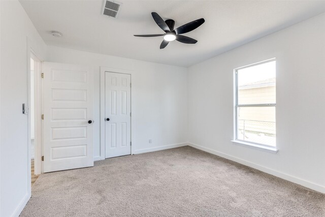 spare room featuring ceiling fan, a wealth of natural light, and carpet floors