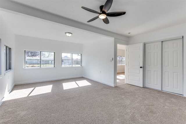 carpeted spare room with ceiling fan and a healthy amount of sunlight