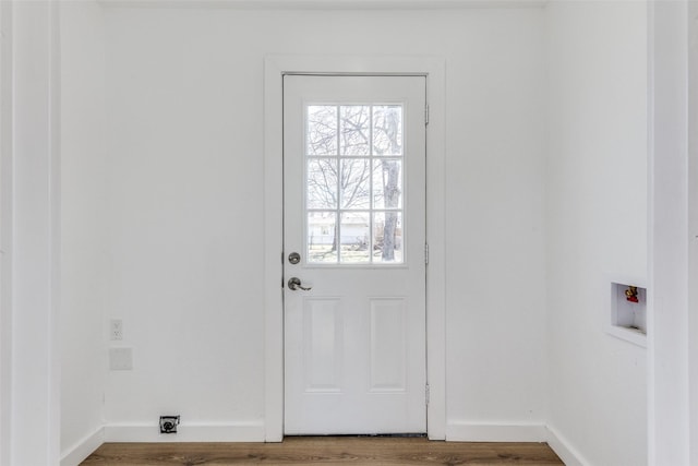 doorway to outside with baseboards and wood finished floors