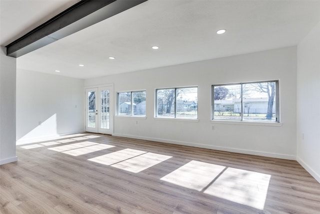 empty room with plenty of natural light, french doors, and wood finished floors