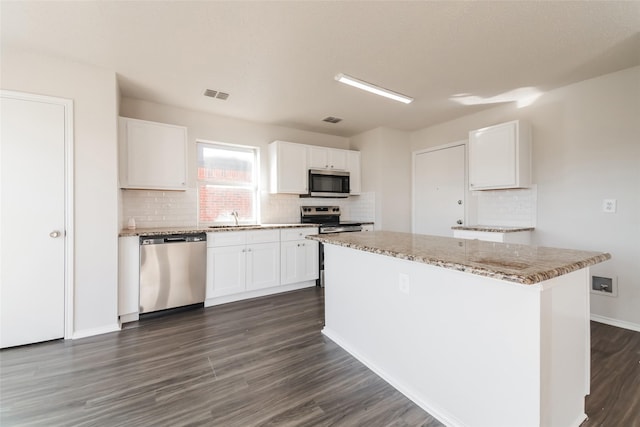 kitchen with white cabinets, a center island, and appliances with stainless steel finishes