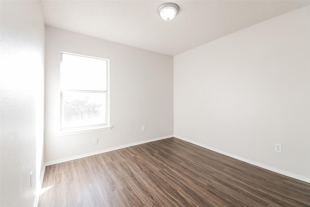 unfurnished room featuring dark wood-type flooring