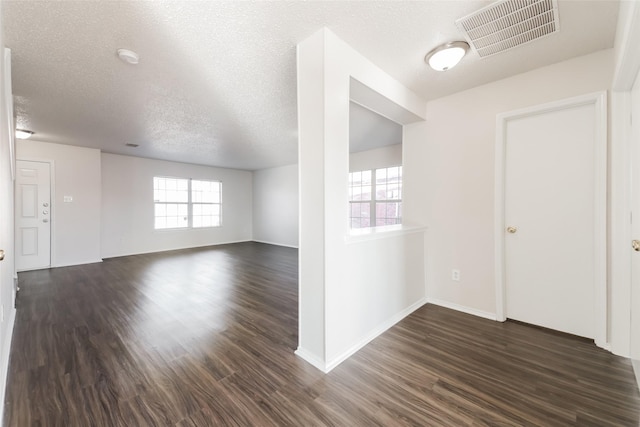 unfurnished room featuring a textured ceiling and dark hardwood / wood-style floors