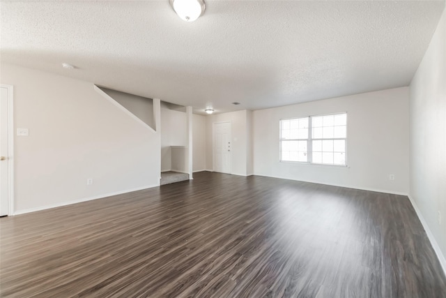 unfurnished living room with a textured ceiling and dark hardwood / wood-style floors