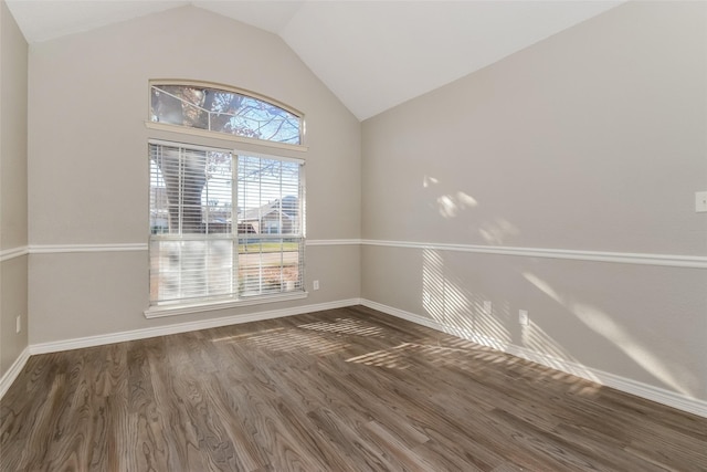 empty room with dark hardwood / wood-style flooring and vaulted ceiling