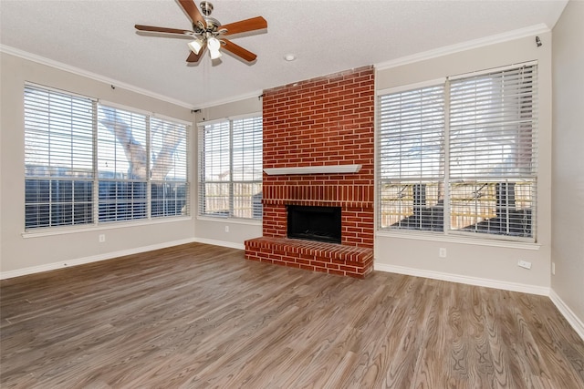 unfurnished living room with a brick fireplace, ornamental molding, a textured ceiling, and wood-type flooring