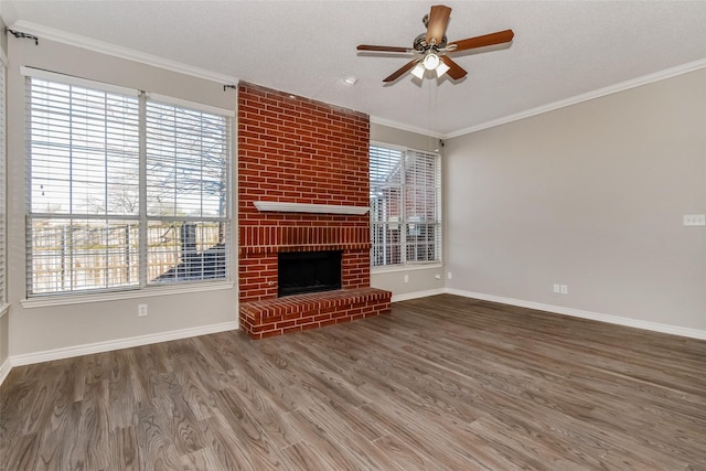 unfurnished living room featuring ceiling fan, a brick fireplace, plenty of natural light, and wood-type flooring