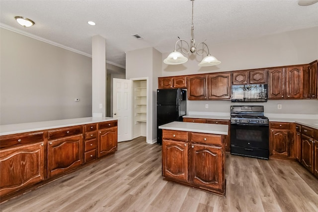 kitchen featuring decorative light fixtures, black appliances, a textured ceiling, and light wood-type flooring