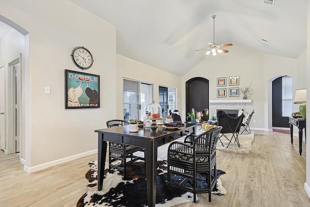 dining area with a wealth of natural light, vaulted ceiling, and light wood-type flooring