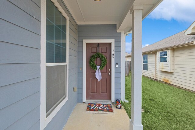 property entrance featuring a lawn