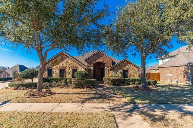 single story home featuring a front lawn